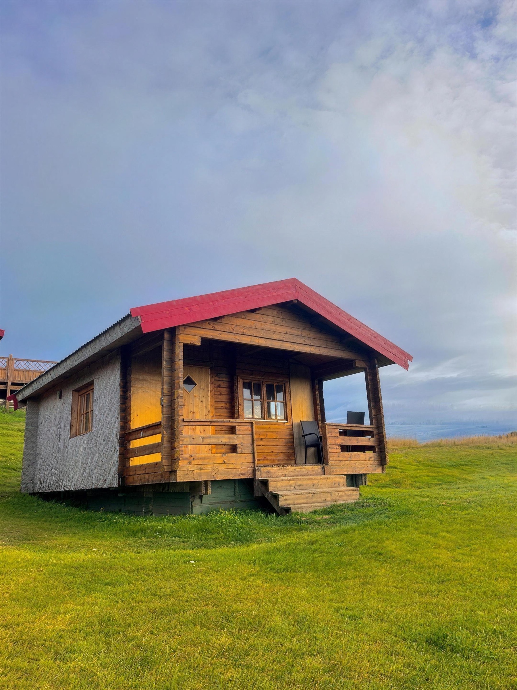 The cottage for three at Nýpugarðar, seen across the field behind it